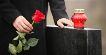 Flores vermelhas em túmulo. Saiba mais sobre funerais em diferentes países.