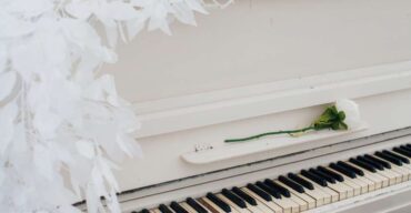 Piano branco com uma rosa branca em cima
