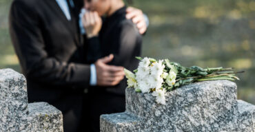 Casal dando um abraço em uma cerimônia de enterro