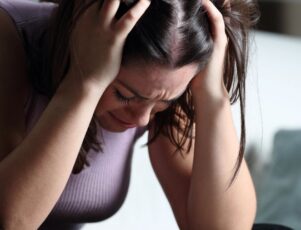 Entenda o que é luto antecipatório com a Funerária Pax Rio 24h! Mulher chora com as mãos na cabeça, representando a dor do luto antecipatório.